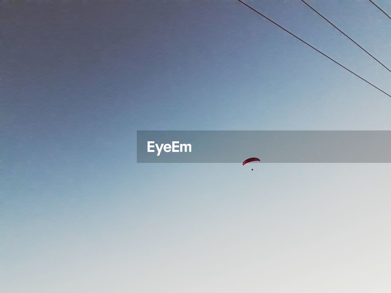 PERSON FLYING KITE AGAINST CLEAR SKY