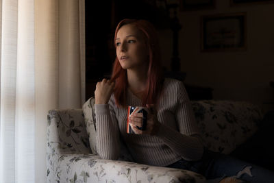 Portrait of young woman using mobile phone at home