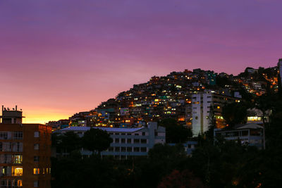 Illuminated cityscape against sky at night