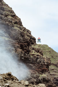 Rock formation on sea against sky