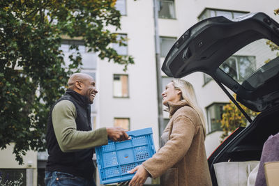 Low angle view of mature man giving crate to woman