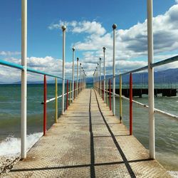 Empty pier over sea against sky