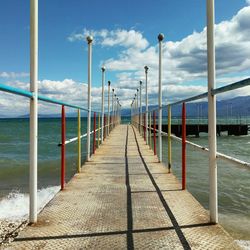 Empty pier over sea against sky