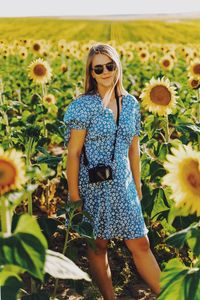 Midsection of woman standing in sunflower field