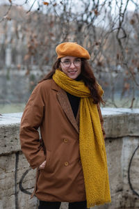 Portrait of woman standing by tree during winter