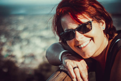 Close-up portrait of smiling woman wearing sunglasses