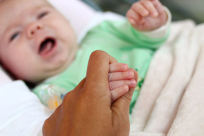 Close-up of baby hand on bed