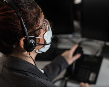 Close-up of businesswoman wearing mask working at office