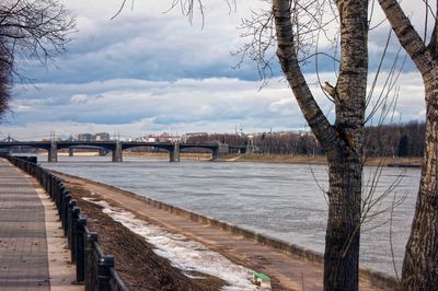 Bridge over river in city against sky