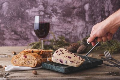 Wensleydale cheese with cranberries, red wine, honey, nuts, raisins on wooden cutting board. 