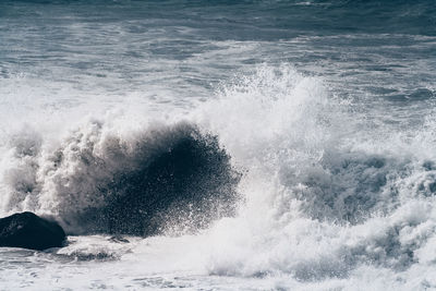 Waves splashing on sea against sky