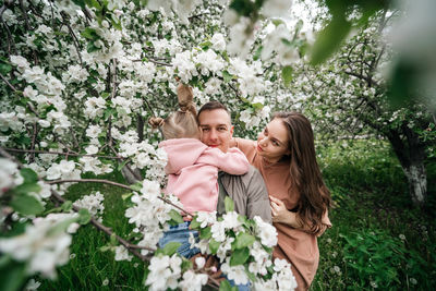 Family mom mom baby daughter in the garden blooming apple trees