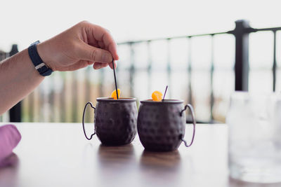 Close-up of hand holding tea cup on table