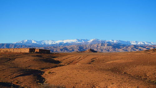 Scenic view of desert against clear blue sky