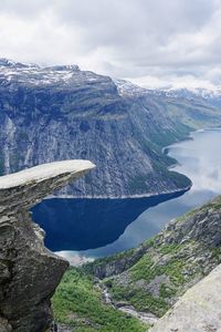 A stone ledge on mt skjeggedal, located near the city of odda in norway, rises above lake rasengan