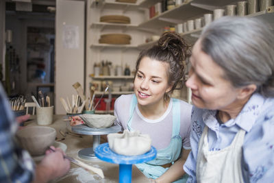 Friends looking at camera while sitting on table