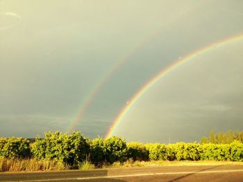 Rainbow over landscape against sky