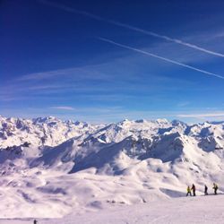 Scenic view of snow mountains against blue sky