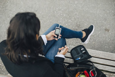 High angle view of man photographing using mobile phone