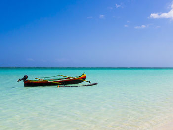 Boat in sea against blue sky