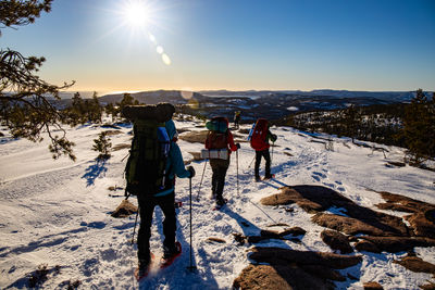 Rear view of people walking on snow covered landscape