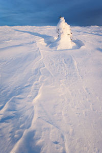 Snow covered landscape against sky during winter