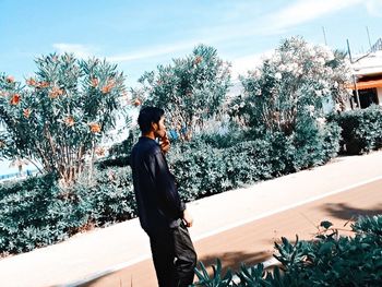 Man standing by tree against sky