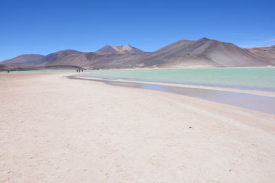 Scenic view of desert against clear blue sky