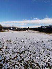 Scenic view of snowcapped field against sky