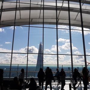 Silhouette people seen through glass window