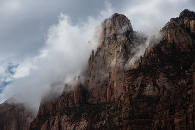 Low angle view of mountain against sky during foggy weather