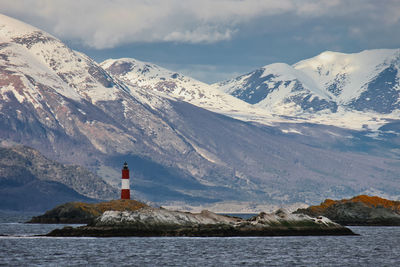 Scenic view of snowcapped mountains by sea against sky