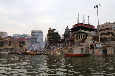 River amidst buildings in city against sky