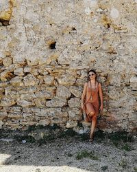 Full length of young man standing against wall
