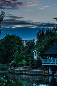 Trees and buildings against sky during sunset