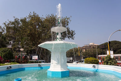 Fountain in swimming pool against clear blue sky