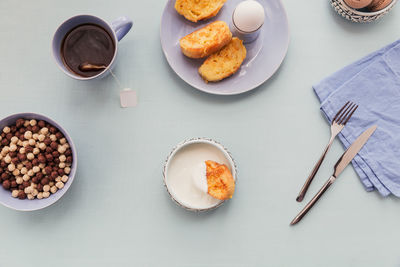 Breakfast with fried croutons, yogurt and black tea on light wooden background. summer country food