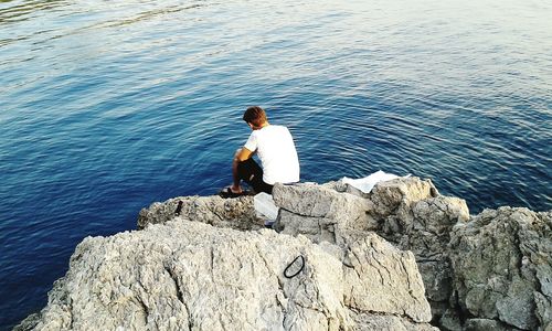 Woman standing on rocks by sea