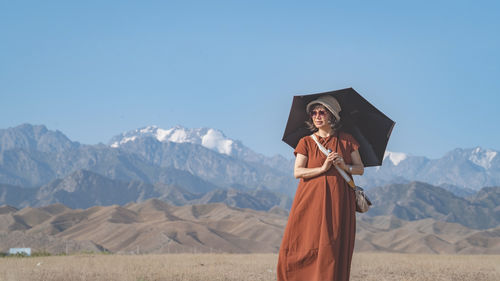 Low angle view of woman standing against mountain