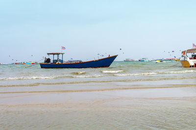 Boat moored in sea against clear sky