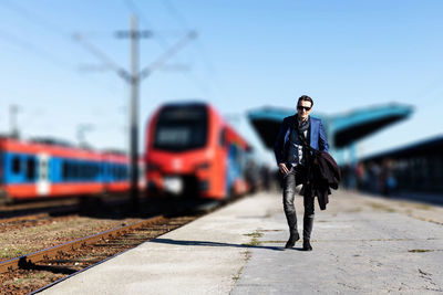 Man standing on train at railroad station platform