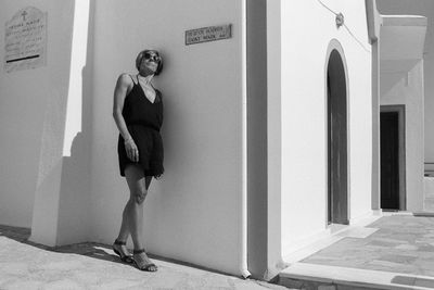 Full length of young woman standing by the wall