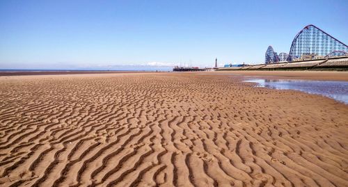 Scenic view of sandy beach against clear sky