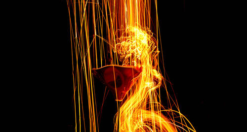 Close-up of illuminated fire against black background