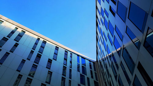 Low angle view of modern building against clear blue sky