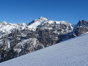 Snowcapped mountains against clear blue sky