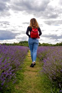 Full length rear view of woman walking on field