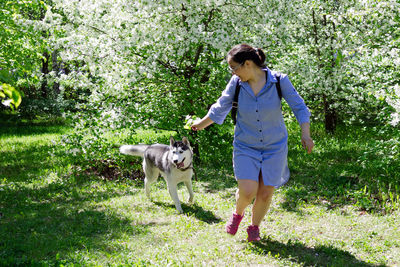 Full length of woman with dog against plants