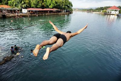 Full length of shirtless man diving in lake