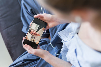 Midsection of woman talking on video call at home